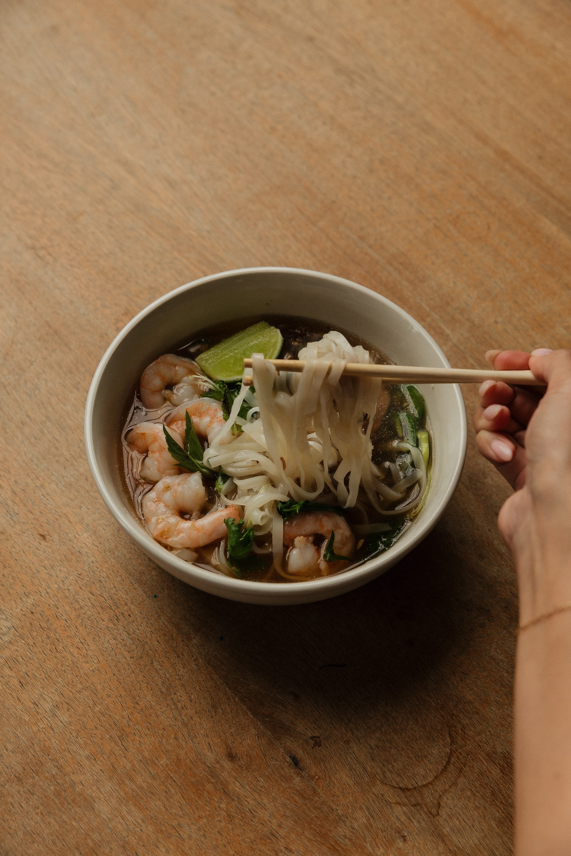 Bowl of shrimp noodle soup with chopsticks