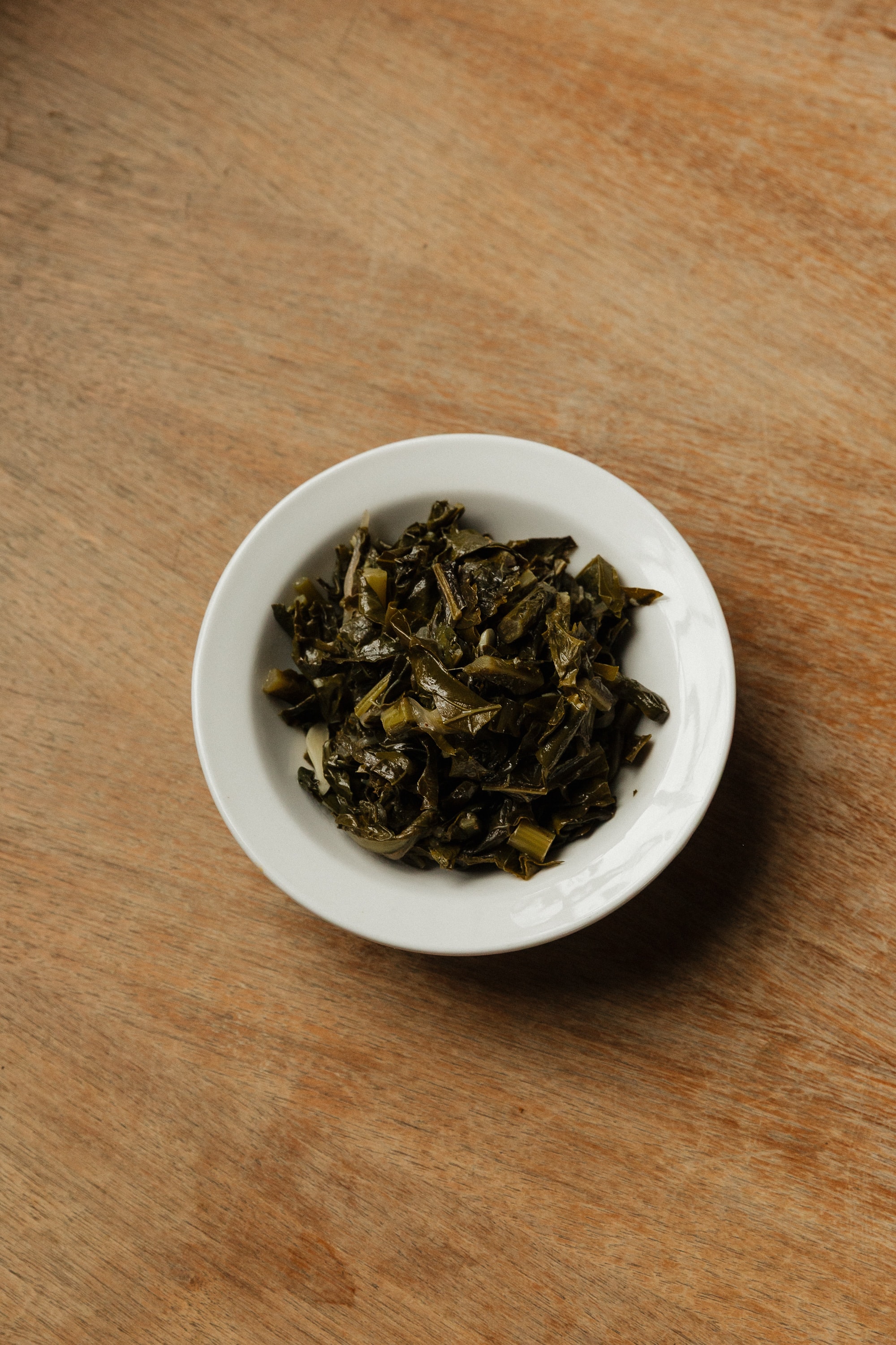 Slow-cooked collard greens in a white bowl